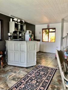 a living room with a white cabinet and a rug at Ollava Guesthouse in Simonʼs Town