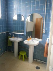 a blue tiled bathroom with two sinks and a mirror at El Refugio del Dragón in Arcones