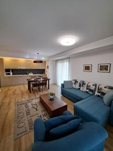 a living room with blue couches and a table at Foxxy Luxury Apartments in Skopje