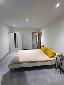 Un dormitorio con una cama grande con una almohada amarilla. en Brand new apartment in Mindelo, en Mindelo