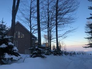 Une église dans la neige avec des arbres devant elle dans l'établissement Cottage apartments at Lake Huron, à Midland