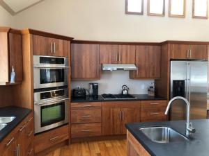 une cuisine avec des armoires en bois et des appareils en acier inoxydable dans l'établissement Cottage apartments at Lake Huron, à Midland