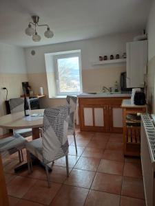 a kitchen with a table and chairs and a table and a window at NORDIQUES DE LA WELCHE in Orbey