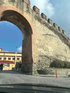 an arch in a brick wall next to a building at Kimon Penthouse in Thessaloniki