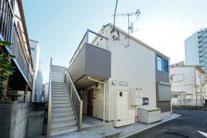 a building with a staircase leading to a garage at Zenith Garden TOGOSHI in Tokyo