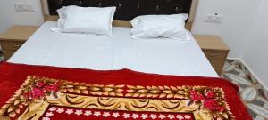 a bed with a red and white blanket on it at Amit home stay in Jhūsi +5 photos