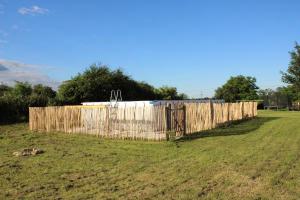 a wooden fence in the middle of a field at La Bergerie maison 2 chambres dans le village de Palleau, Les Blés Dorés maison 3 chambres et les Graines de Lin maison 3 chambres à Corgengoux avec piscine, verger, terrasses aménagées, parking voitures, terrain de pétanque, à vous de choisir votre gîte in Palleau