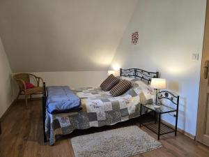 Un dormitorio con una cama y una mesa con una lámpara. en Le Batteux chez bidou, en Quesnoy-le-Montant