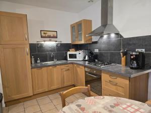 Una cocina con gabinetes de madera y un microondas blanco. en Le Batteux chez bidou, en Quesnoy-le-Montant 13 fotos más