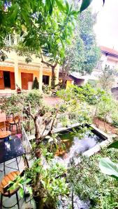 a garden with a pond in front of a building at Lee Homestay in Hanoi