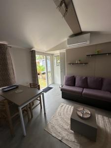 salon z kanapą i stołem w obiekcie Mobil home les Embruns w mieście Lège-Cap-Ferret