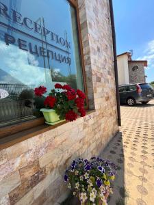 a window with flowers on the side of a building at Апартхотел Созополски перли in Sozopol