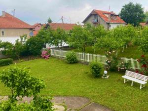 a yard with a white fence and a bench at Aurora Apartment in Smederevo