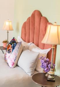 a bed with white pillows and a red chair at Luxury suite near Church Street in Stellenbosch