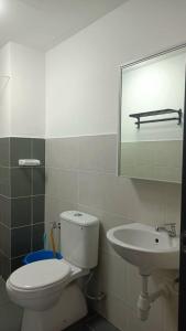 a bathroom with a toilet and a sink at D'Kiela Homestay in Kampung Dengkil