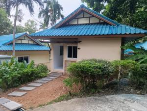 a house with a blue roof at Phuket Jungle Experience Resort in Karon Beach