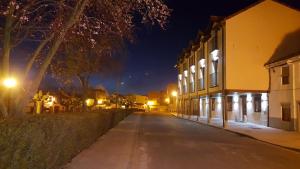 an empty street at night with lights on at La Casa de los Soportales in Mansilla de las Mulas