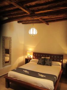 ein Schlafzimmer mit einem großen Bett und einem Kronleuchter in der Unterkunft Sa Tanca den Marines ETV 1272 E in Sant Carles de Peralta