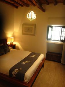 ein Schlafzimmer mit einem Bett und einem Kronleuchter in der Unterkunft Sa Tanca den Marines ETV 1272 E in Sant Carles de Peralta