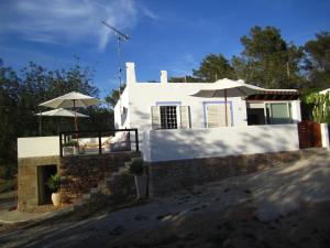 ein weißes Haus mit zwei Sonnenschirmen und einer Treppe in der Unterkunft Sa Tanca den Marines ETV 1272 E in Sant Carles de Peralta