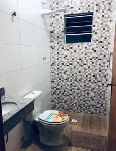 une salle de bain avec toilettes et lavabo dans l'établissement Sobrado com Piscina Oliveira, à Mongaguá