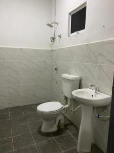 a bathroom with a toilet and a sink at Awienna House in Kota Kinabalu +3 photos