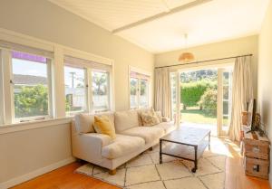 Waiheke IslandにあるTaimana Beach Front, Surfdaleのソファとテーブルのあるリビングルーム