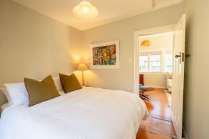 Waiheke IslandにあるTaimana Beach Front, Surfdaleの部屋に白いベッドがある寝室
