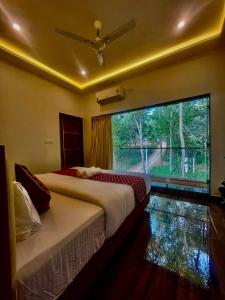 Postel nebo postele na pokoji v ubytování Riverside Resort Yelagiri