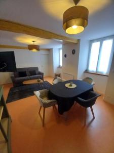 a living room with a table and a couch at appartement coeur de ville Laruns 2 ou 3 personnes in Laruns