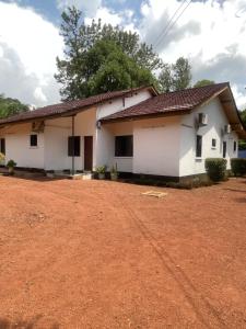 una casa con un camino de tierra delante de ella en Home away from home, en Moshi