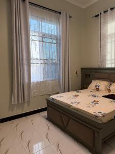 a bedroom with a bed and a large window at MASAI Apartment Goba in Dar es Salaam +46 photos