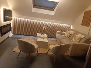a living room with a couch and a table and chairs at La mezzanine 159 in Namur