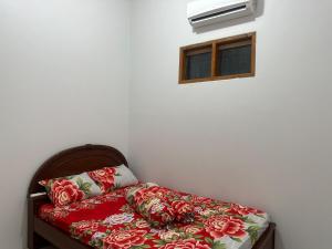 a bed with a red blanket and a window at gypsea house in Batukaras