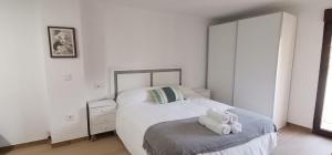 a white bedroom with a bed with two stuffed animals on it at Casa Dolores in Villahermosa del Río
