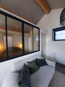 un soggiorno con divano e alcune finestre di Le cottage , logement individuel de plain pied a Villeneuve d'Ascq