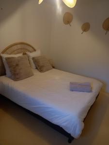 ラランスにあるappartement centre ville de Laruns 2 ou 3 personnesのベッド(白いシーツ、青いタオル付)