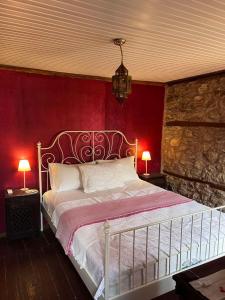a bedroom with a white bed with a red wall at Luxury suites in Villa Anasia, Olympia in Skotina