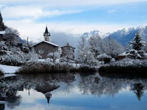 a church covered in snow next to a lake at Casa Vacanze da Emanuela in Darfo