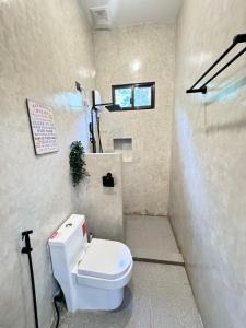 a bathroom with a white toilet and a shower at Pio Transient House in Tanay +14 photos