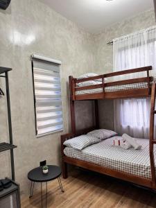 a bedroom with two bunk beds and a table at Pio Transient House in Tanay
