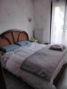 ルマンにあるLE MANS 24 heures auto moto Grand prix de Franceの木製のヘッドボードが付いた大きなベッドのある寝室