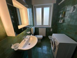 ein Badezimmer mit Waschbecken und Toilette und einem Fenster in der Unterkunft Appartamento 3 camere con vista mare - Agenzia Cocal in Caorle + 10 Fotos