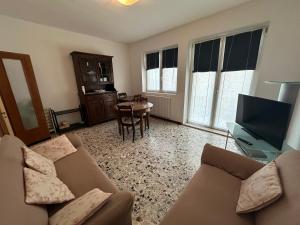 ein Wohnzimmer mit Sofa und Fernseher in der Unterkunft Appartamento 3 camere con vista mare - Agenzia Cocal in Caorle