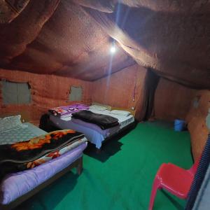 a room with two beds and a chair in it at Chandra Bhaga camps in Tāndi +12 photos