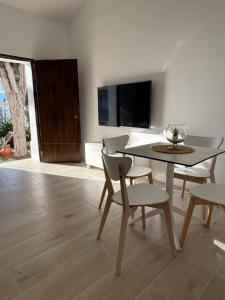 a dining room with a table and chairs and a tv at Apartamentos Murcia río in Murcia