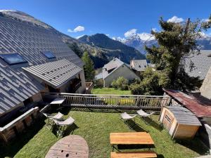 dziedziniec z krzesłami i stołem oraz góry w obiekcie Chalet des Grangettes avec jardin, sauna et Appli Roadbook - Huez w mieście LʼHuez