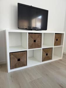 a tv sitting on top of a white entertainment center at Apartamentos Murcia río in Murcia