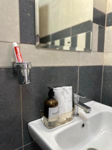 a bathroom sink with a bottle of soap and towels at Spacious studio Ruaka in Ruaka