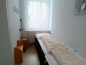 ein kleines Zimmer mit einem Bett und einem Fenster in der Unterkunft FeWo Radau in Bad Harzburg